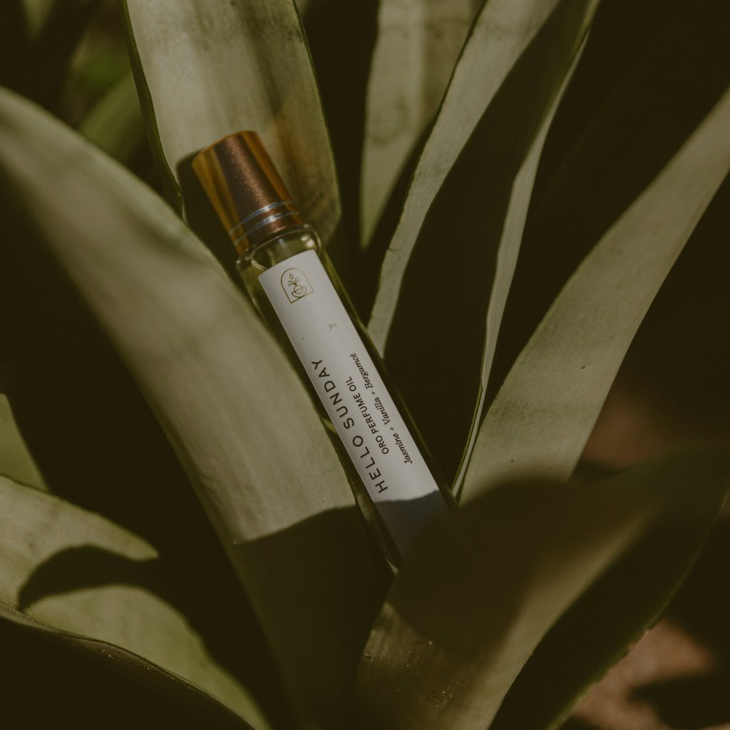 Hello Sunday perfume oil laying in a leaves